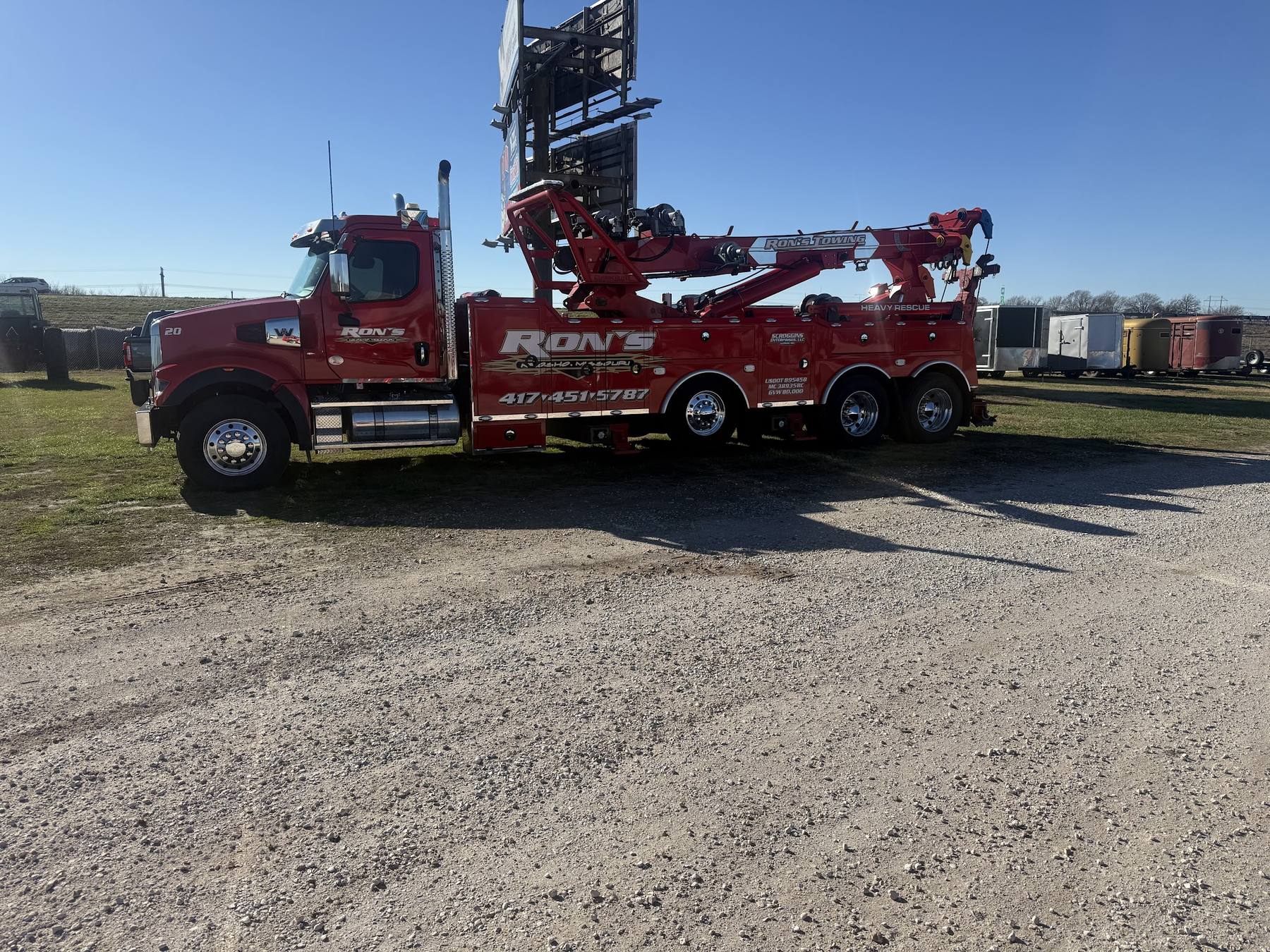 Red Ron's Towing tandem-axle wrecker lettered heavy rescue, parked by the highway